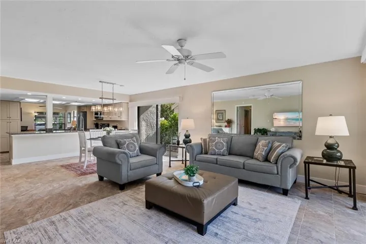 Living room featuring light tile patterned floors and ceiling fan