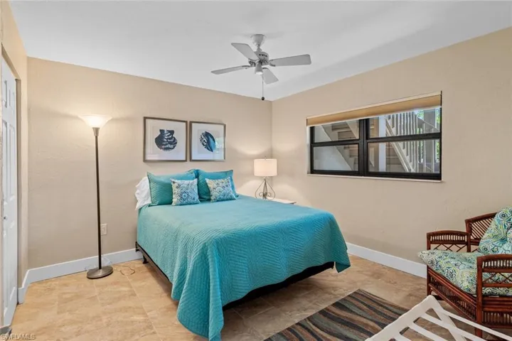 Bedroom with tile patterned floors, a closet, and ceiling fan