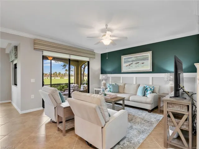 Living Room with Tile Flooring, Board & Batten Wall Treatment, Crown Molding, Ceiling Fan, & Screened In Lanai with Golf Course View