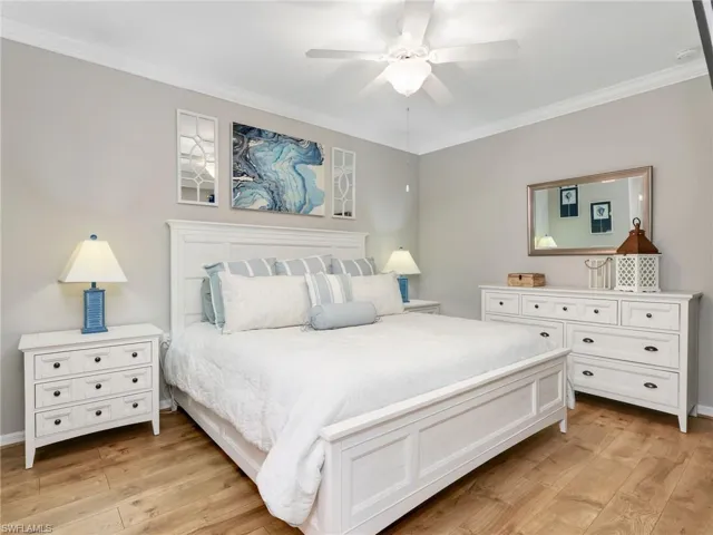 Primary Bedroom with Laminate Flooring, Crown Molding, & Ceiling Fan