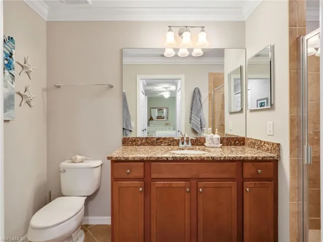 Primary Bathroom with Tile Floors, Granite Countertop, Mirrored Medicine Cabinet, & Tiled Shower with Glass Shower Enclosure