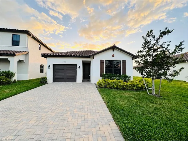 Mediterranean / spanish home with a garage and a yard