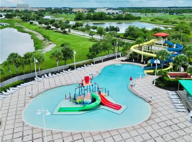 View of pool featuring a water view, a water slide, and a playground