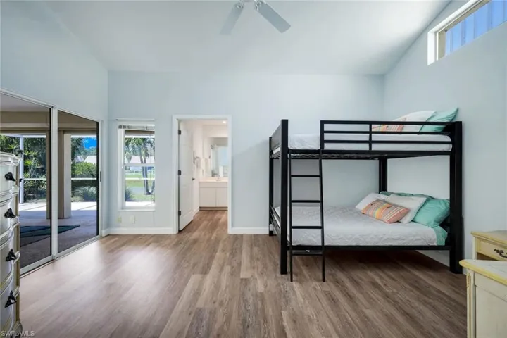 Access the lanai from the primary suite featuring vaulted ceilings and lake views.