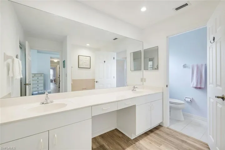 Ensuite primary bathroom features dual sinks and separate toilet room.