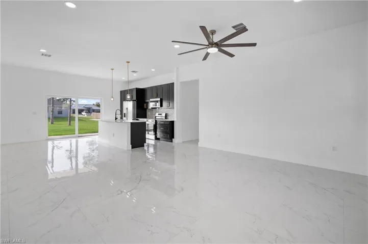 Unfurnished living room featuring light marble finish flooring, recessed lighting, and a ceiling fan