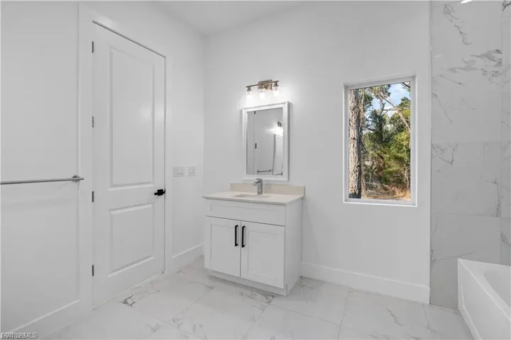 Bathroom with vanity and light marble finish floors