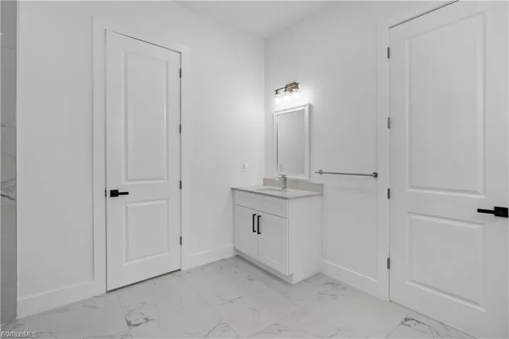 Full bathroom with vanity and light marble finish flooring