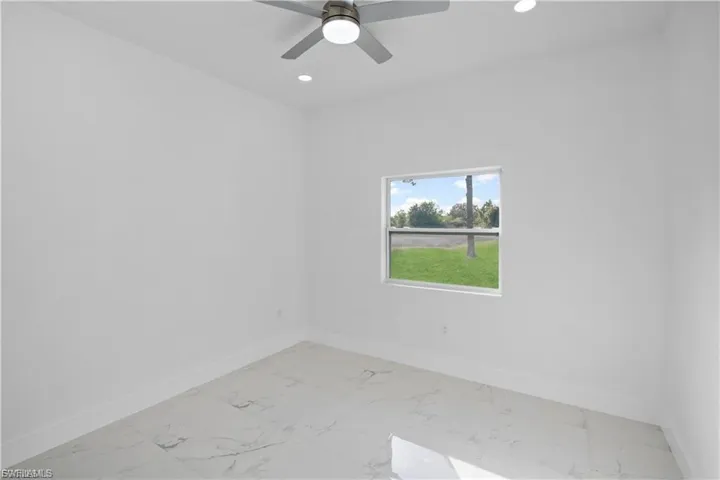 Unfurnished room featuring light marble finish floors, recessed lighting, and a ceiling fan