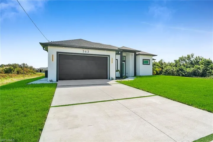 View of front of house with a garage and a front yard