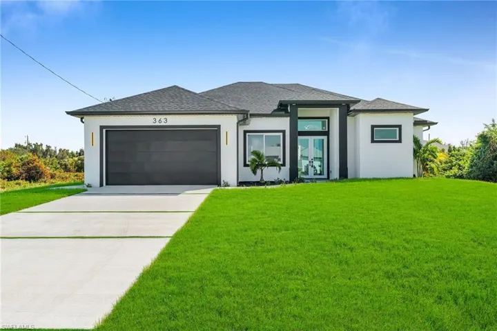 Prairie-style house featuring a garage and a front lawn