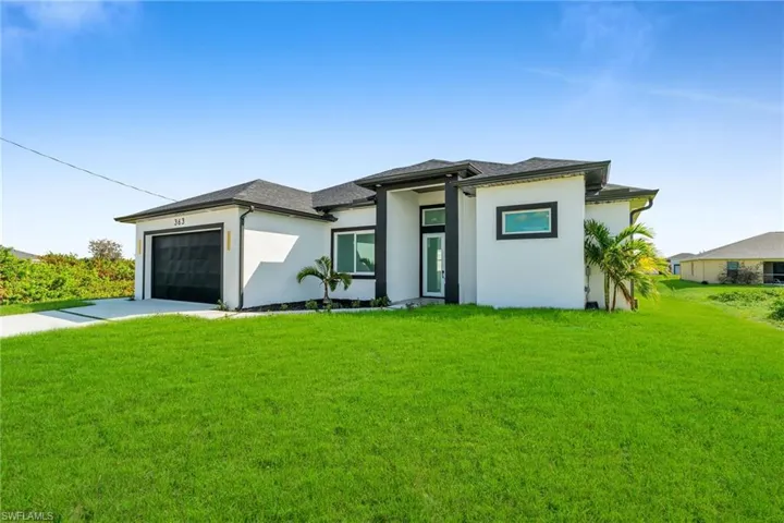Prairie-style home featuring a garage and a front lawn
