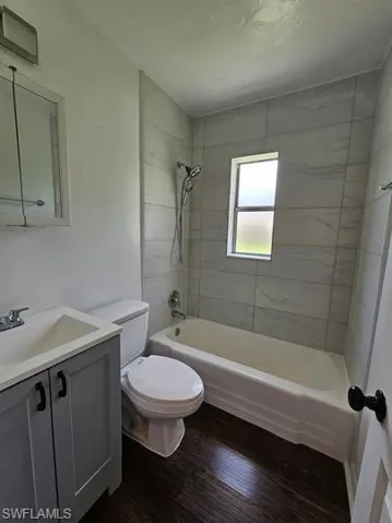 Full bathroom featuring shower / washtub combination, vanity, and dark wood finished floors