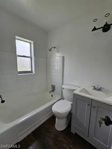 Full bath with vanity, shower / washtub combination, and dark wood-style floors