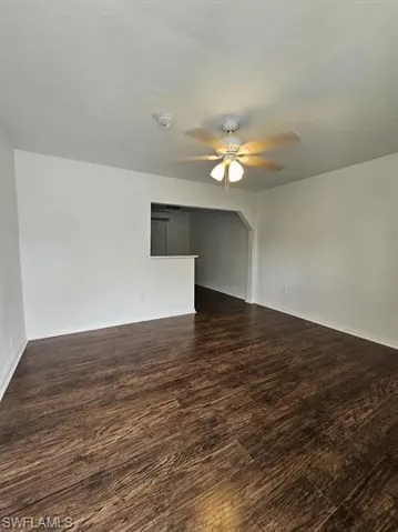 Unfurnished room featuring dark wood finished floors and a ceiling fan