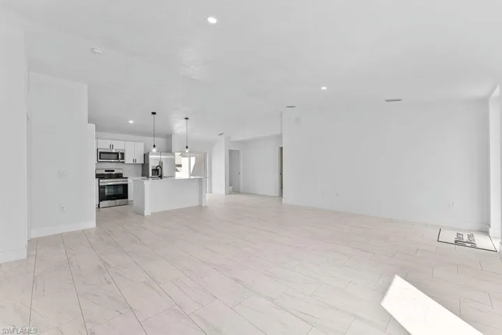 Unfurnished living room with recessed lighting and vaulted ceiling