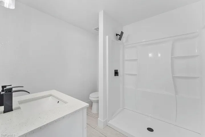 Full bathroom with vanity and a shower stall