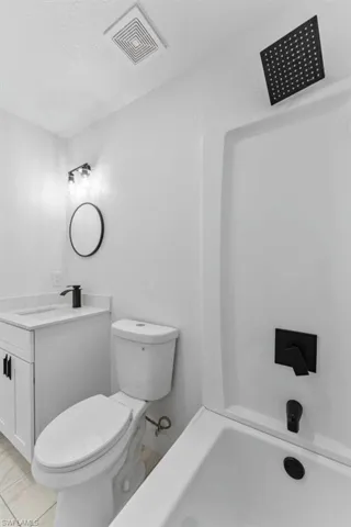 Full bathroom with vanity, a textured ceiling, bathing tub / shower combination, and a textured wall