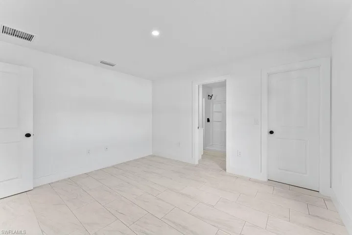 Unfurnished bedroom with recessed lighting and ensuite bath