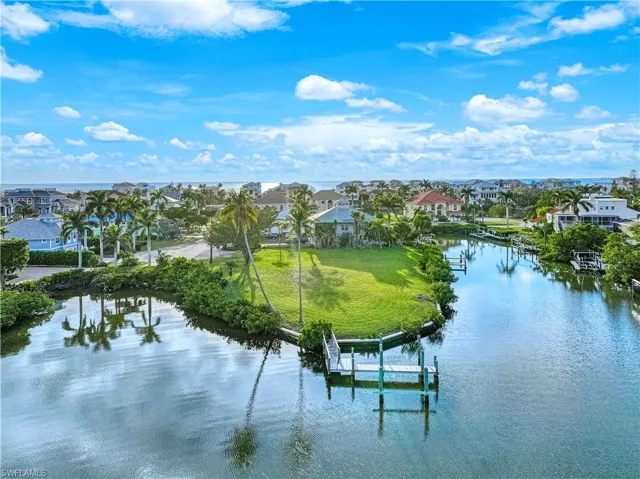 Water view with a dock, nearby suburban area, and boat lift