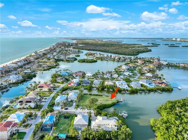 Aerial view of property and surrounding area with nearby suburban area and a large body of water