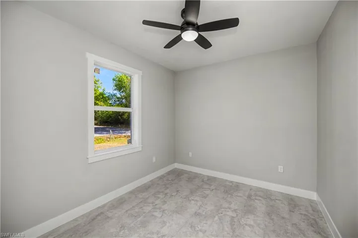 Spare room with baseboards and a ceiling fan
