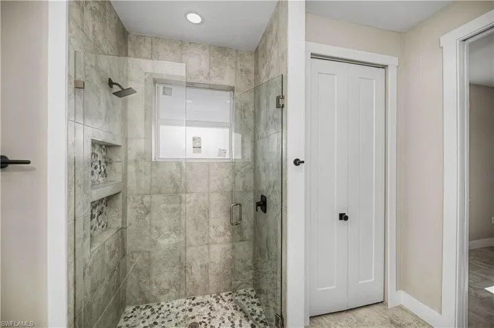 Bathroom featuring a stall shower and baseboards