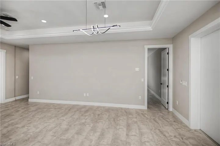 Spare room featuring a tray ceiling and a ceiling fan