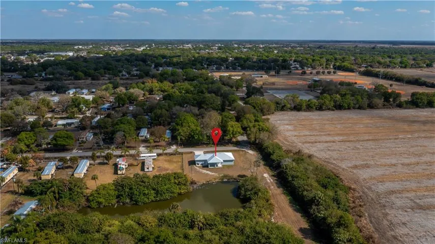 Aerial view of property and surrounding area featuring a large body of water and a tree filled landscape