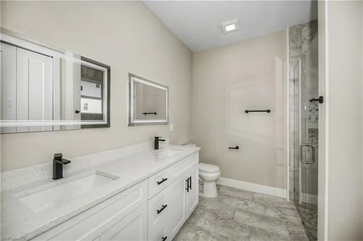 Bathroom featuring a shower stall and double vanity