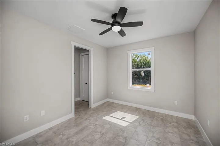 Empty room with baseboards and a ceiling fan