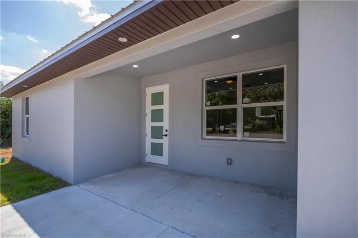 View of exterior entry with a patio area and stucco siding