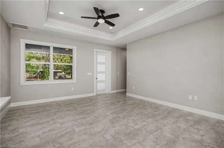Empty room with a ceiling fan, recessed lighting, and a raised ceiling