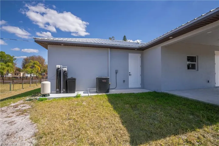 Back of property featuring a patio, stucco siding, and a metal roof