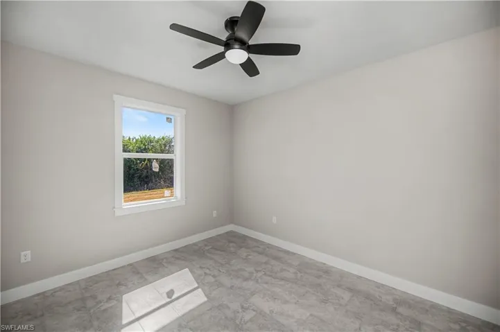 Spare room featuring baseboards and ceiling fan