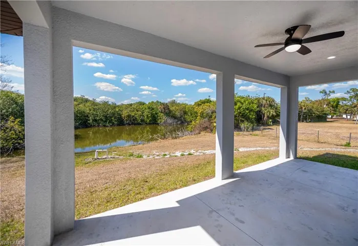 View of patio with ceiling fan and a water view