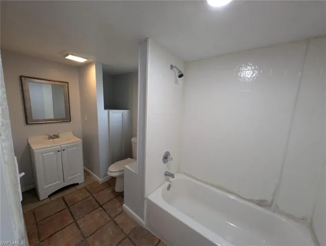 Full bathroom featuring shower / bath combination, vanity, toilet, and tile patterned flooring