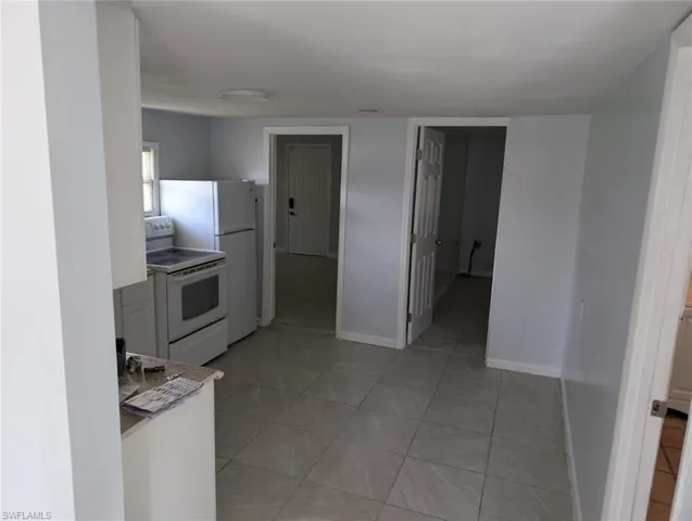 Kitchen with white range with electric cooktop and light tile patterned floors