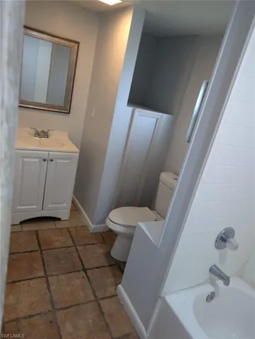 Full bathroom with  shower combination, toilet, tile patterned floors, and vanity
