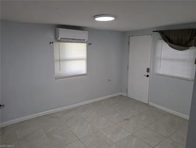 Spare room with light tile patterned floors and a wall mounted AC
