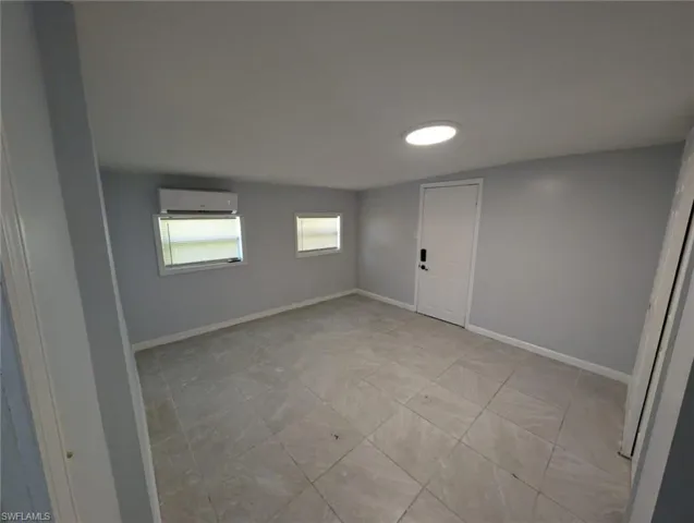 Tiled spare room with a wall unit AC