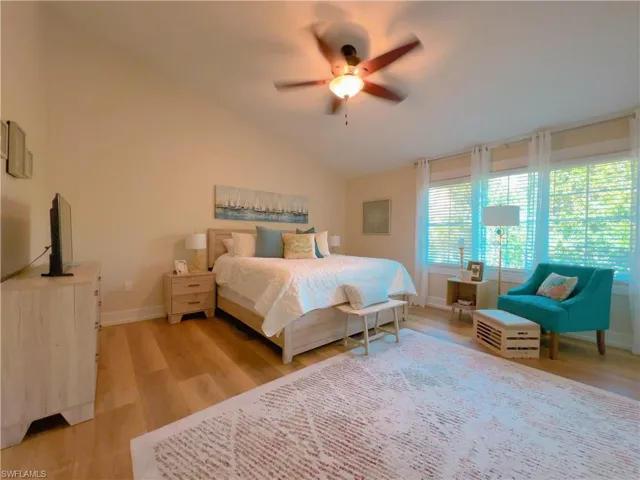 Bedroom featuring lofted ceiling, light wood-style flooring, and a ceiling fan