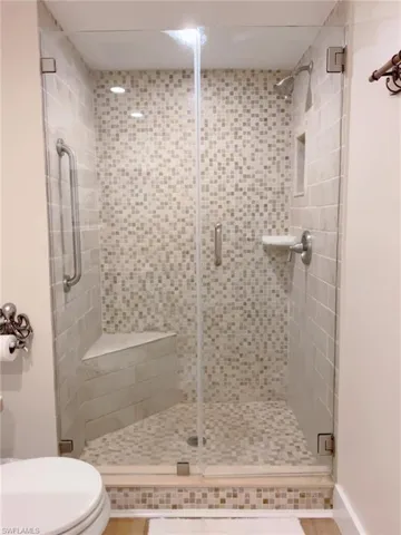Full bathroom featuring a stall shower and toilet