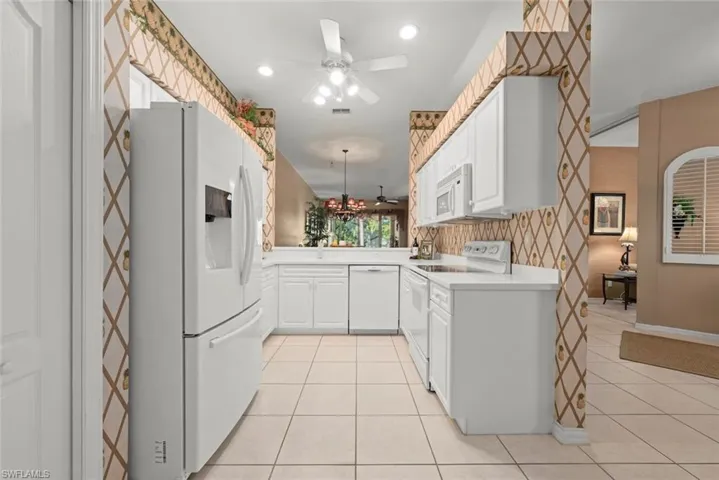 Kitchen featuring white cabinetry, integrated appliances, a tiled floor, and a breakfast bar