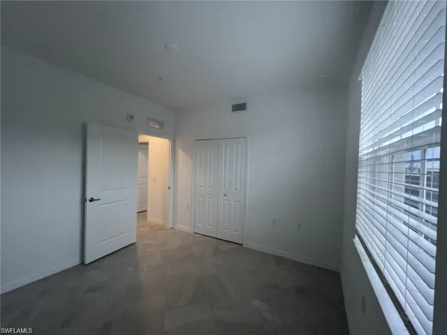 Guest bedroom with a closet and baseboards