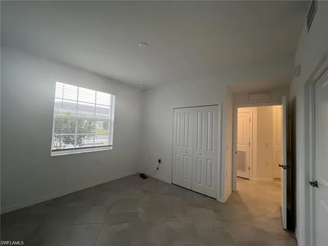 Guest bedroom featuring a closet and baseboards