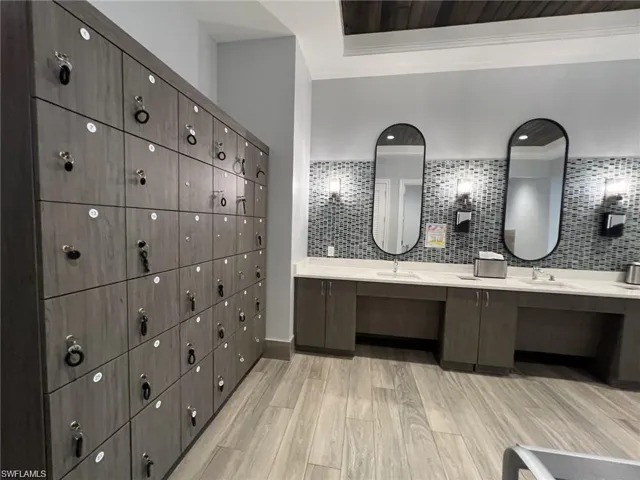 Locker room featuring double vanity and ornamental molding