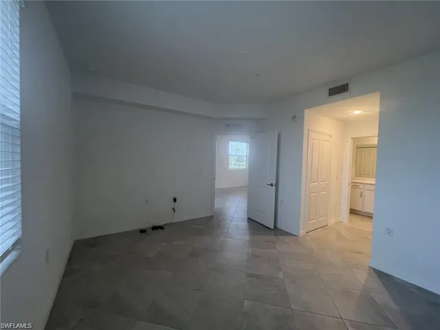 Primary bedroom featuring baseboards and light tile patterned flooring