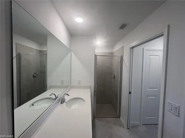 Primary bathroom featuring vanity and a shower stall