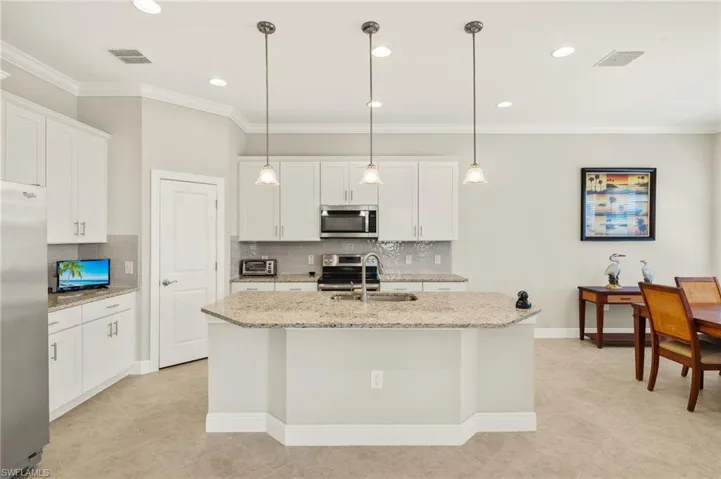 Kitchen with ornamental molding, visible vents, a sink, and appliances with stainless steel finishes